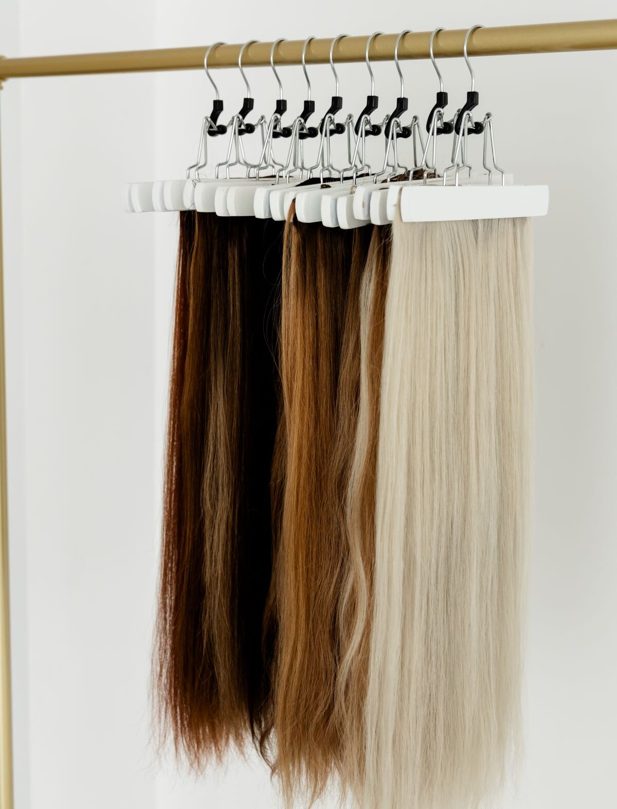Hair extensions in various shades hanging on a rack in Raleigh, North Carolina.