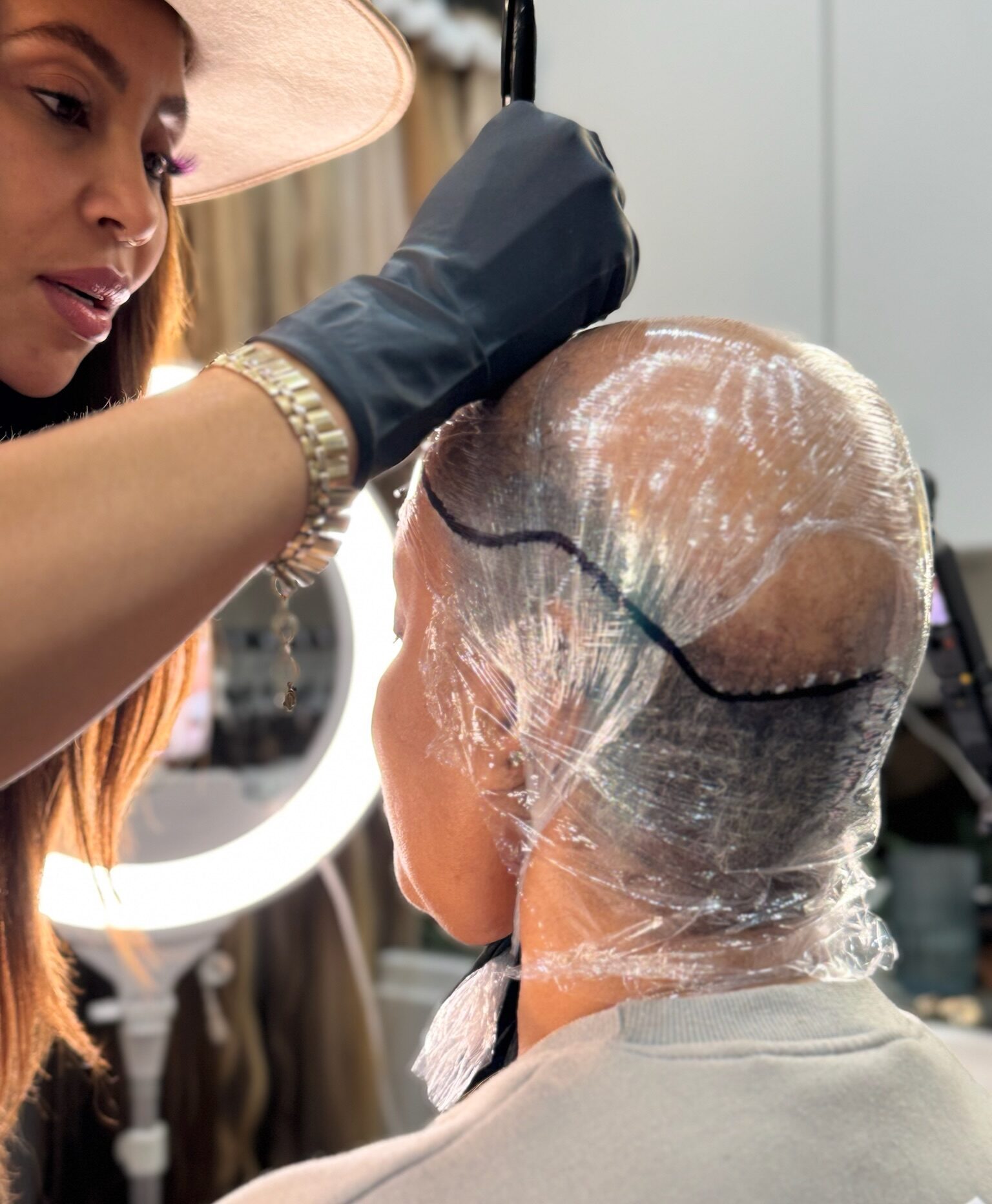 Garnish founder Candice Mot works on a mold on a guest's scalp