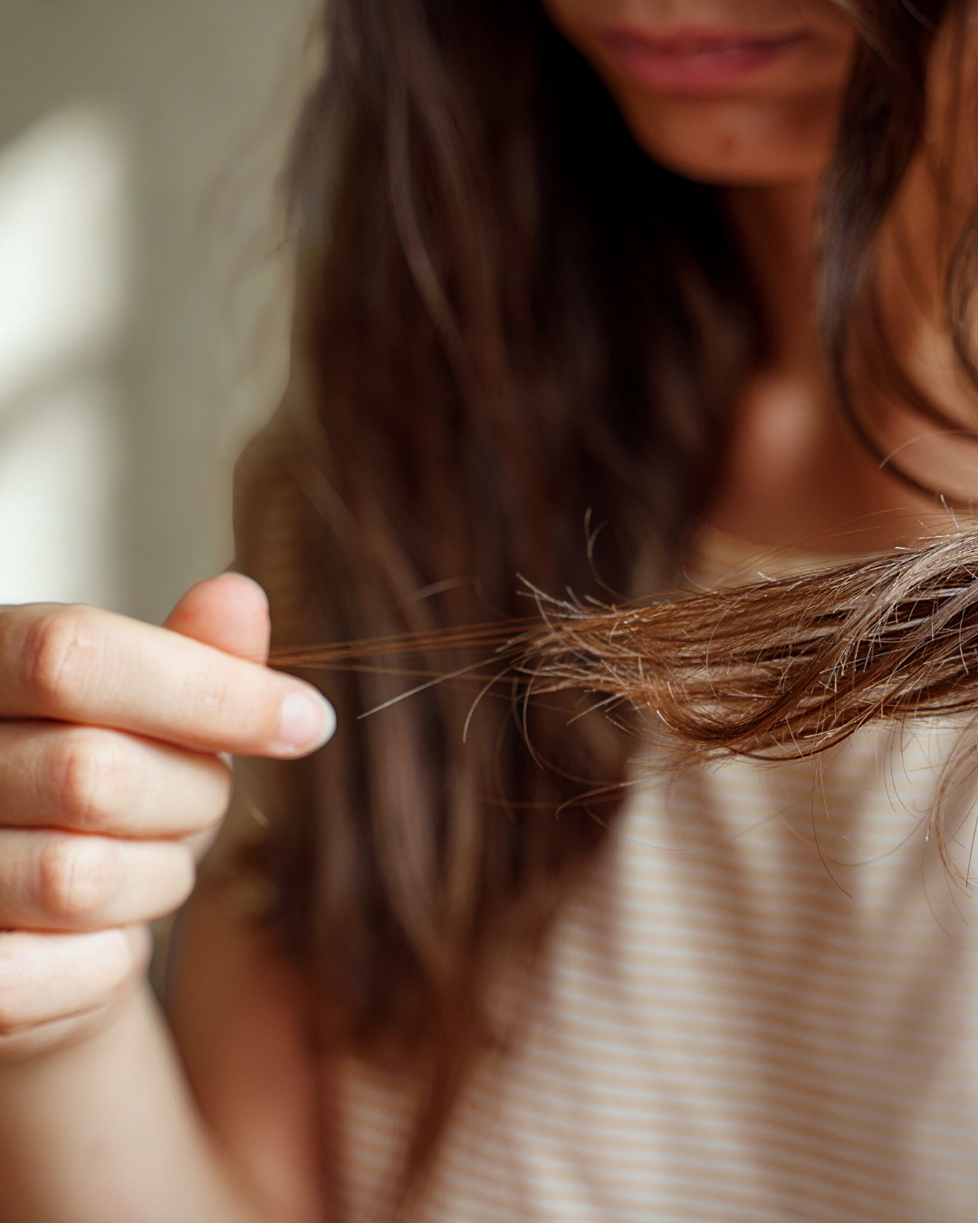 a woman examines hair shedding