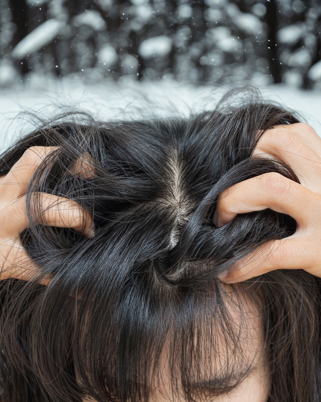 A woman dealing with winter hair loss runs her fingers through her hair