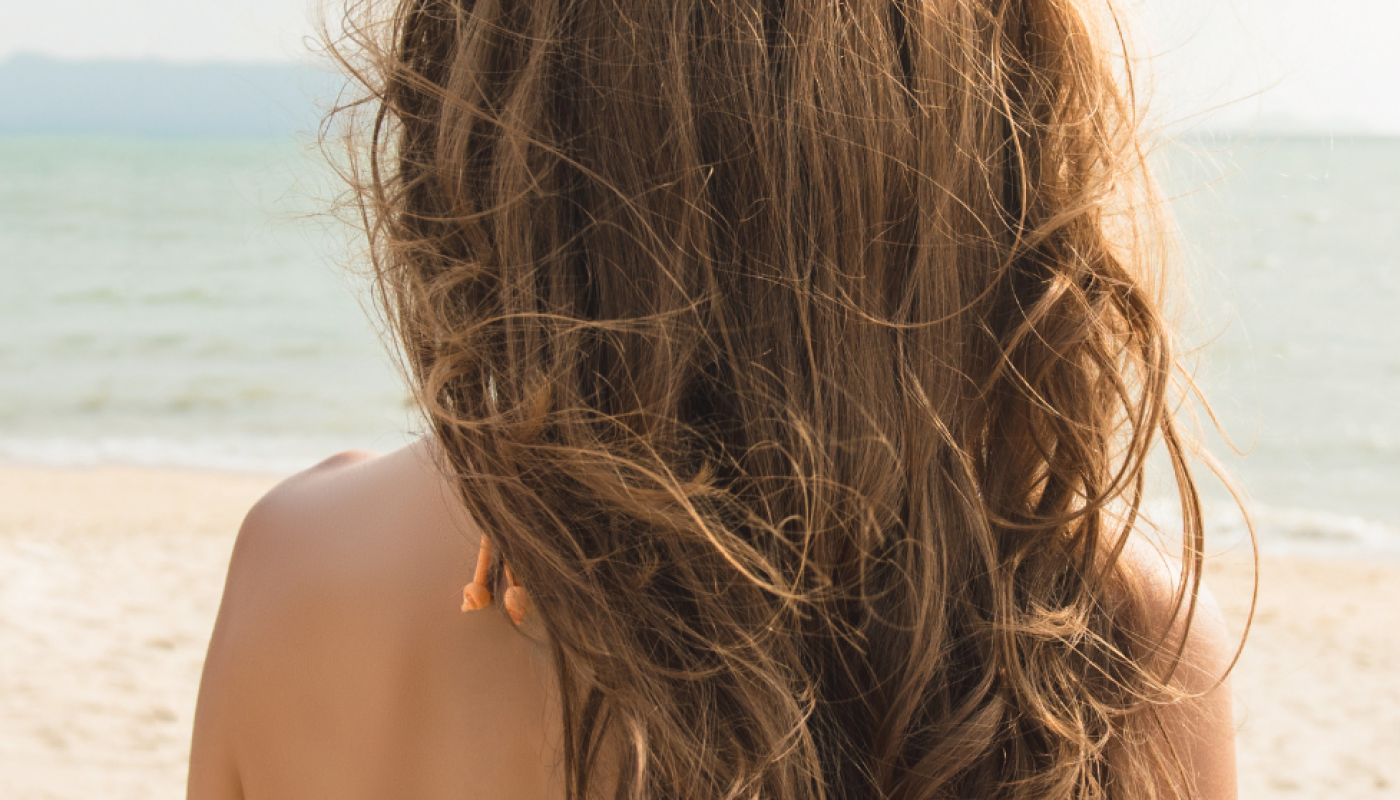 ☀️ Summer Hair Energy☀️ (2) A woman with hair extensions stands facing the ocean